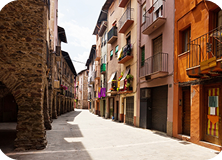 Vista colorida da rua do bairro Pigneto em Roma com murais vibrantes e cafés animados