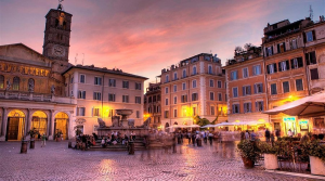 Bunte Kopfsteinpflasterstraße mit Trattorien und Spaziergängern in Trastevere, Rom